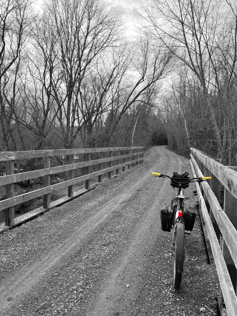 Surly Troll bicycle on a gravel trail leaning against bridge railing. 